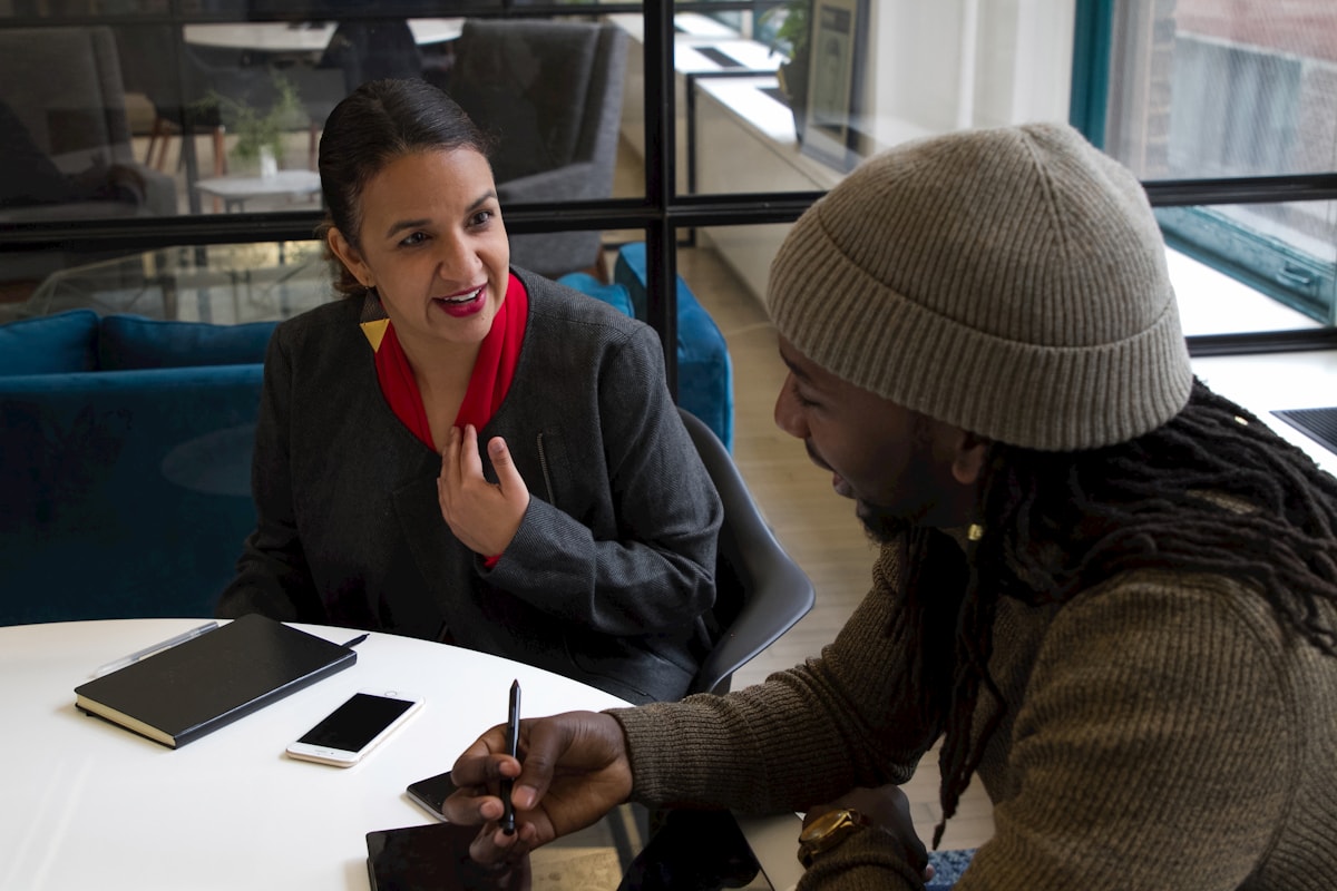 Two colleagues exchanging ideas across a table